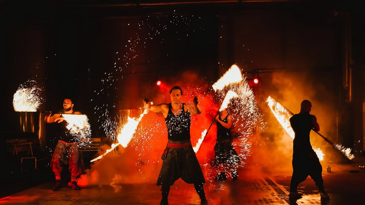 Mehrere Amaterasu-Artisten mit Feuer- und Funkeneffekten auf einer Festivalbühne